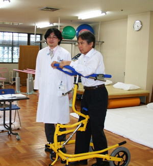 歩行訓練機を紹介するキシ・エンジニアリング株式会社社長